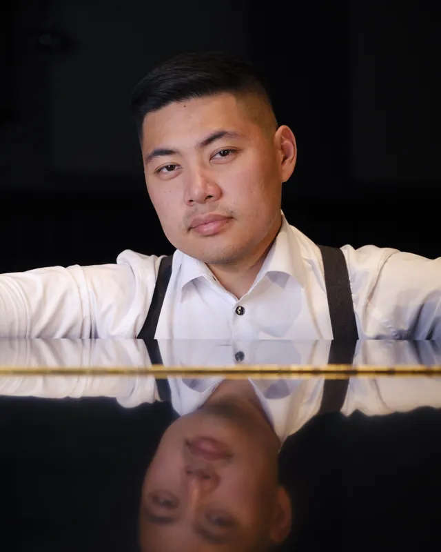 Portrait of Isaac in a white shirt and suspenders